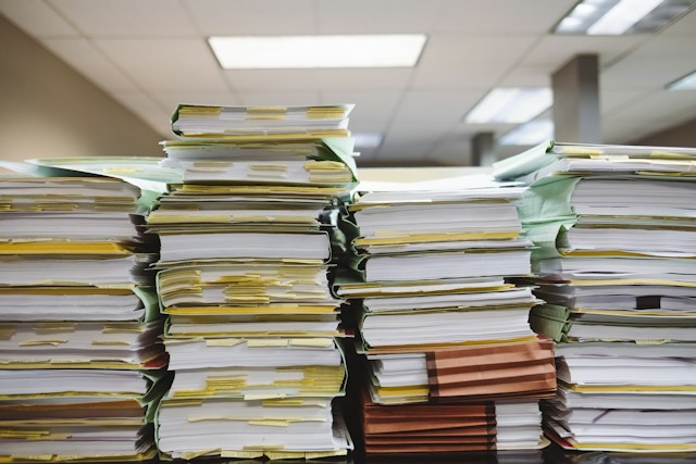 Four stacks of records filled with sticky notes